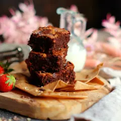 Gestapelte Brownies mit Nüssen und Schokostückchen, dazu frische Erdbeeren. Ein köstliches brownie rezept zum Genießen.