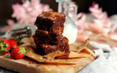 Gestapelte Brownies mit Nüssen und Schokostückchen, dazu frische Erdbeeren. Ein köstliches brownie rezept zum Genießen.
