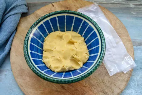 Frischer quiche teig in einer blauen Schüssel, bereit für die Zubereitung einer herzhaften Quiche.