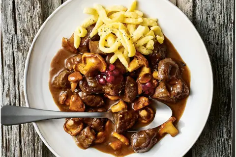 Herzhaftes Rehgulasch mit Rotwein, Pilzen und Preiselbeeren, serviert mit Spätzle. Ein köstliches Rehgulasch Rezept.