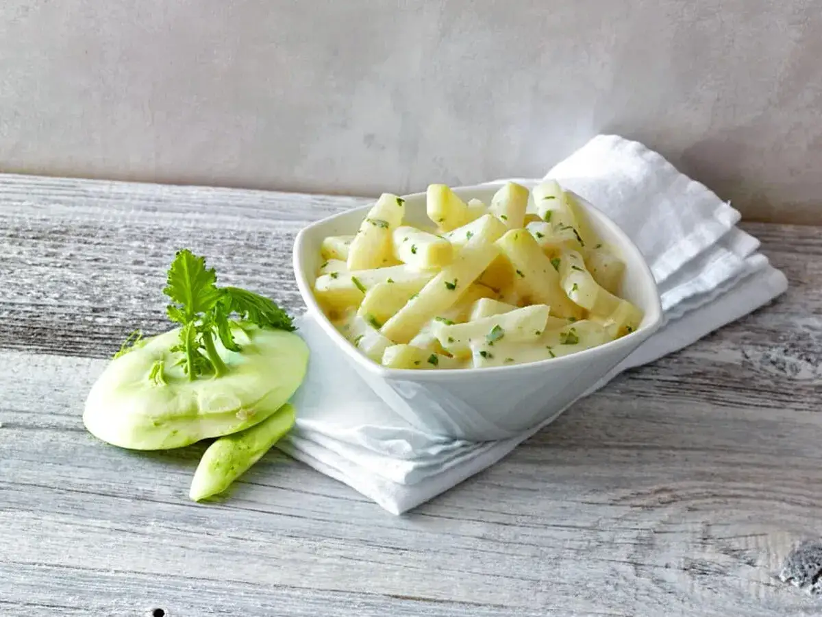 Kohlrabi kochen wie lange? Hier ist ein cremiger Kohlrabieintopf, serviert mit frischen Kohlrabibl&auml;ttern.