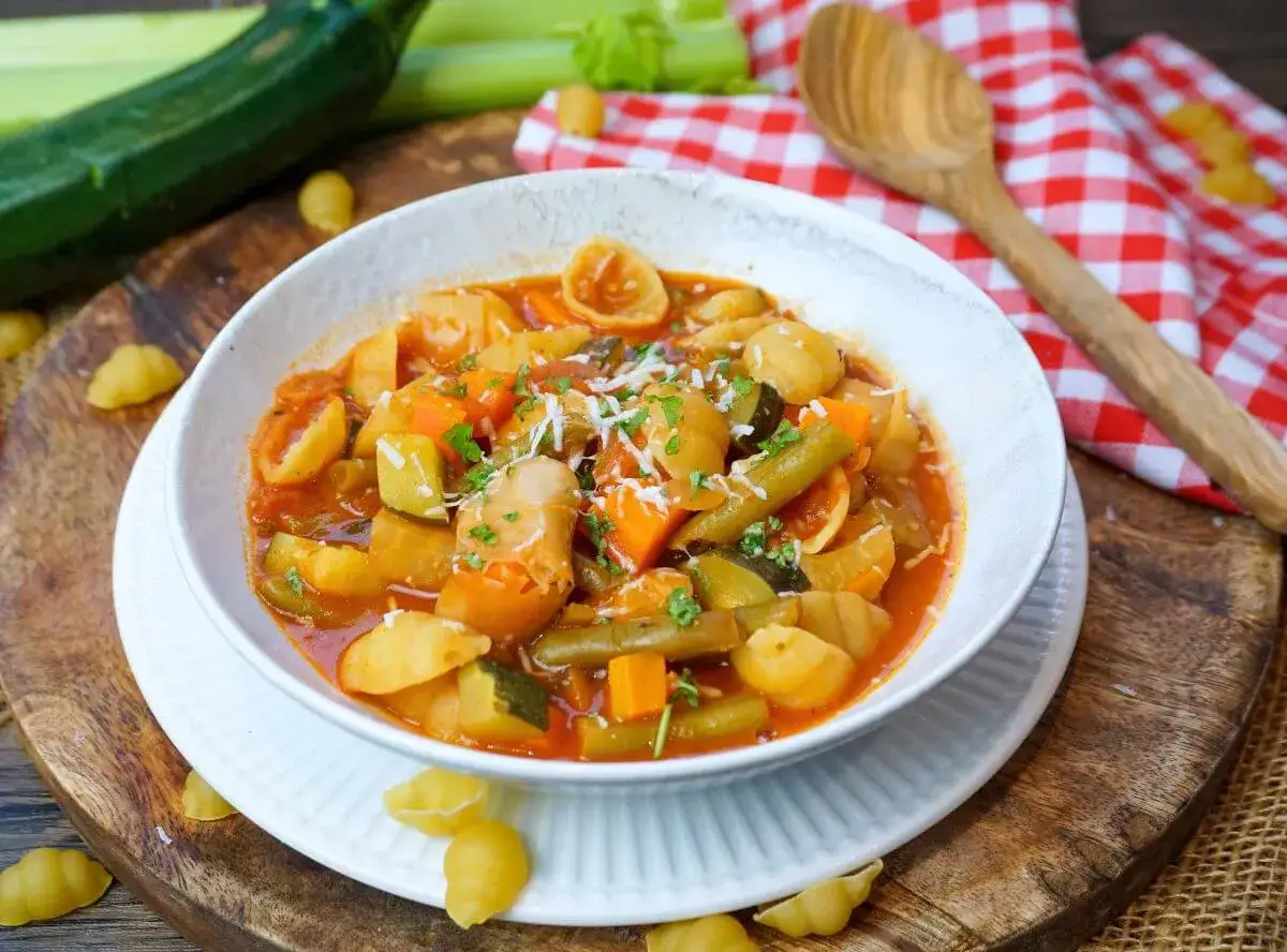 Herzhaftes Minestrone Rezept mit viel Gem&uuml;se und Pasta in einer Sch&uuml;ssel, garniert mit Parmesan.