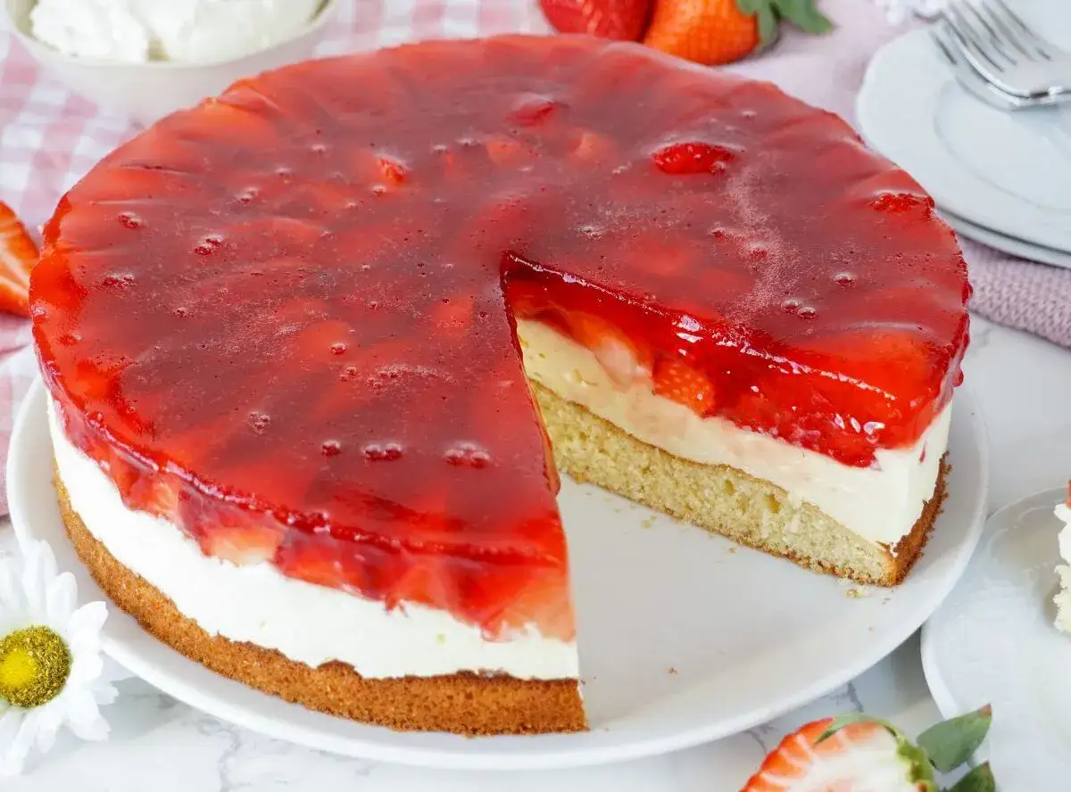 Ein saftiger Erdbeerkuchen mit Sahne und rotem Tortenguss. So lecker kann man mit Erdbeeren backen!