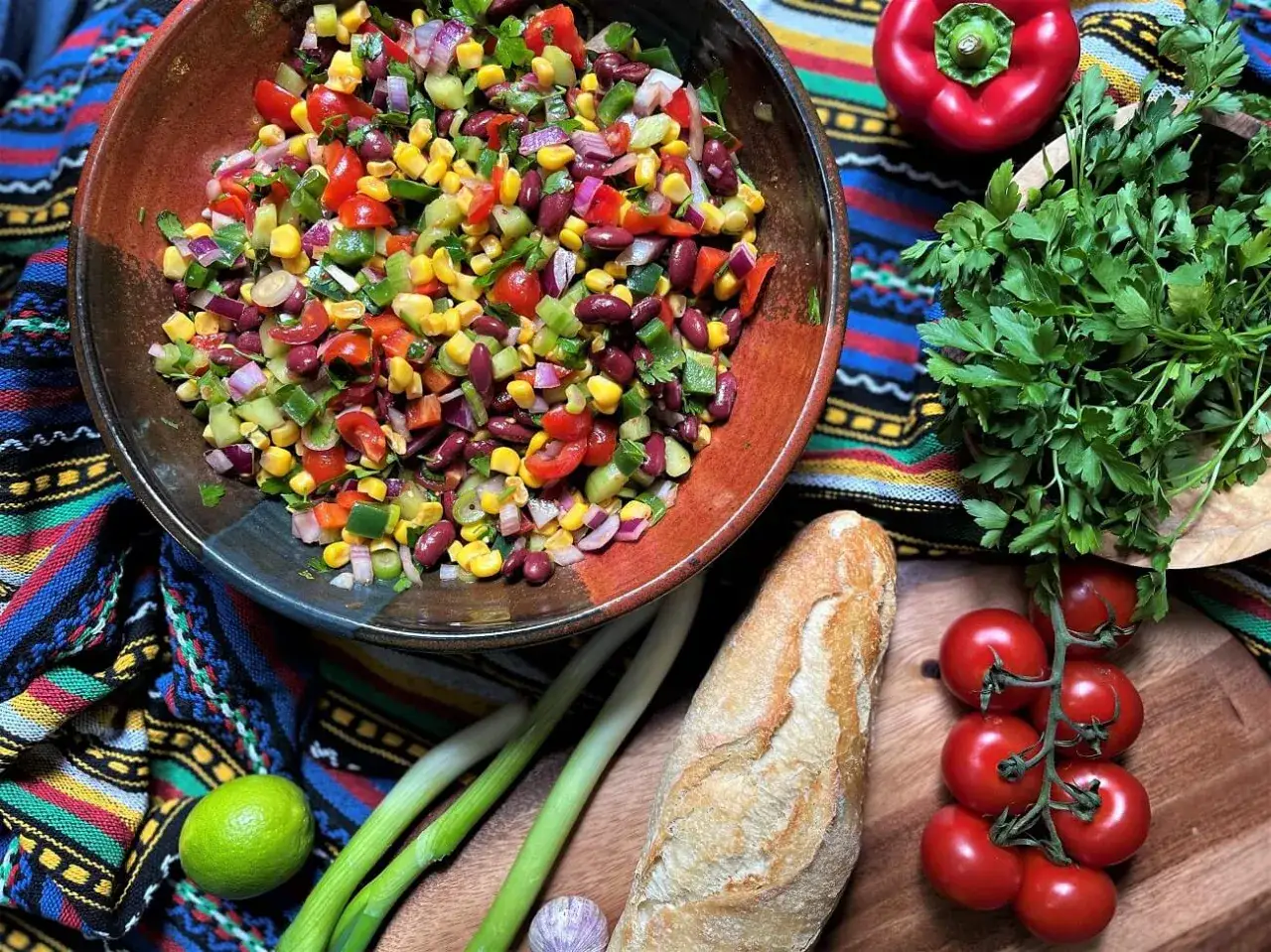 Bunter Salat mit Mais, Bohnen und Gem&uuml;se &ndash; tolle Ideen f&uuml;r Beilagen zum Grillen. Dazu Baguette, Tomaten und frische Kr&auml;uter.